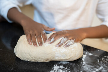 Boy preparing dough on kitchen counter - obrazy, fototapety, plakaty
