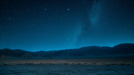 Fototapeta na wymiar Desert with distant mountains under a starry night sky