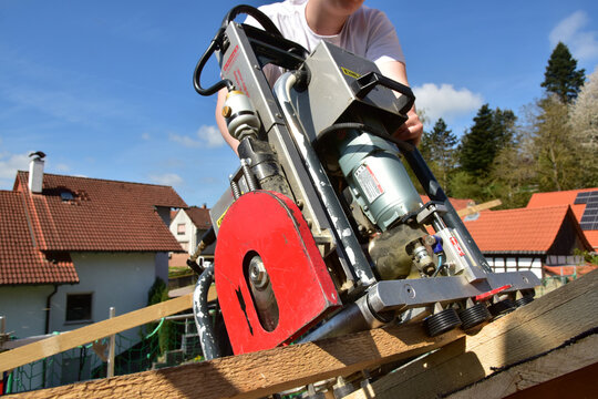 Die Dachlatten eines Steildachs werden vom Dachdecker mit dem Einlattger&auml;t / Einlattblitz mit Kapps&auml;ge halbautomatisch verlegt