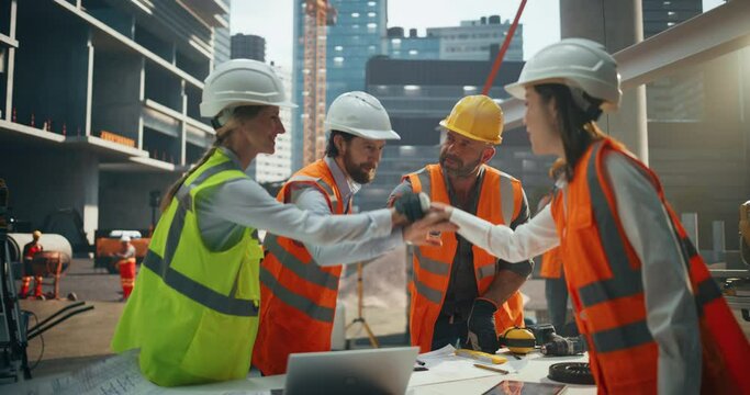 Diverse Female and Male Engineers and Architects Putting Hands Together After a Productive Meeting at a Building Site Area. Specialists Inspiring the Group to Have a Successful Work Day