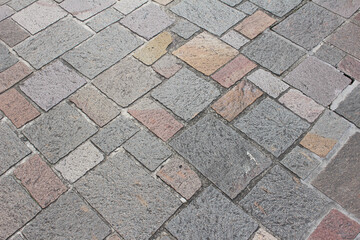 Texture of combination of different size square cobblestones. Pattern of sidewalk tiles in the...