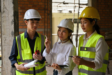 The Specialists using digital tablet inspect the building construction site, Real Estate Project with Civil Engineer and contractor