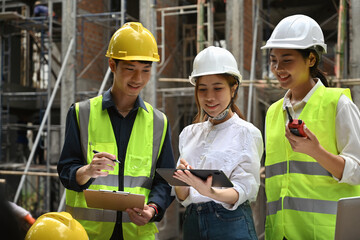 A construction engineer and construction worker talk to the manager on construction site, Quality...