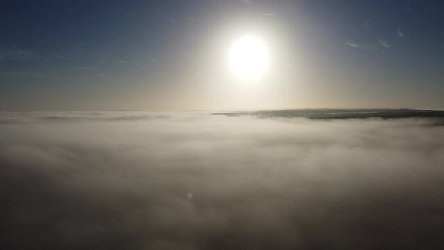 Drone view over a foggy surface on a sunny day