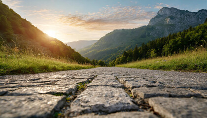 Low level view of empty old paved road in mountain area at sunset