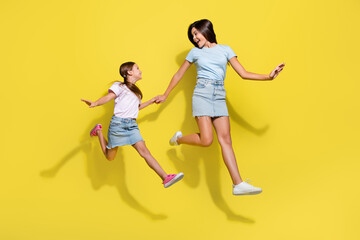 Fototapeta na wymiar Photo of two best girls cousins jump run enjoy time together isolated over bright color background