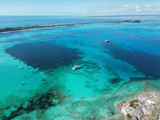 Obraz premium aerial view of the sea with boats in it and a beach below
