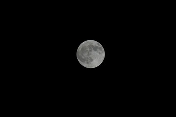 Obraz premium Stunning full moon illuminated against a dark night sky