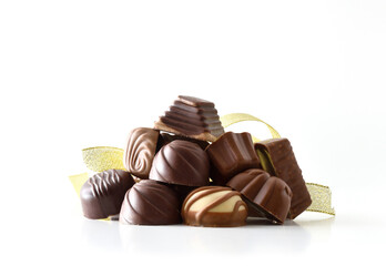 Stack of chocolate bonbons with golden ribbon white isolated background