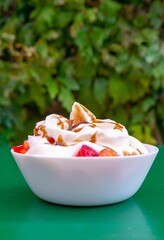 Fresh strawberries with cream and caramel in a white bowl