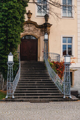 The main entrance to the palace in Krzyzowa with stairs and lanterns and vines in autumn colors. - obrazy, fototapety, plakaty
