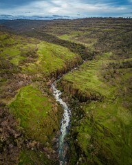 Aerial view of a fast-flowing river winding through a picturesque landscape