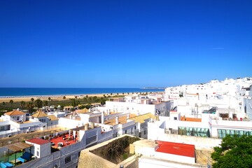 Obraz premium view from the Torre de Guzman tower over the roofs of Conil de la Fronteraand along the beautiful beach Playa los Bateles at the Atlantic Ocean, Costa de la Luz, Andalusia, Spain