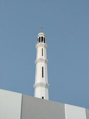 Obraz premium White mosque tower against a blue cloudless sky.
