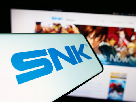 Stuttgart, Germany - 02-06-2024: Smartphone with logo of Japanese video games company SNK Corporation in front of business website. Focus on center-left of phone display.
