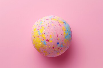 Fototapeta na wymiar A single colorful bath bomb against pink background. Flat lay, top view