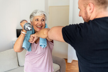 Cropped shot of a young man and old woman bumping elbows. Senior women and fitness trainer...