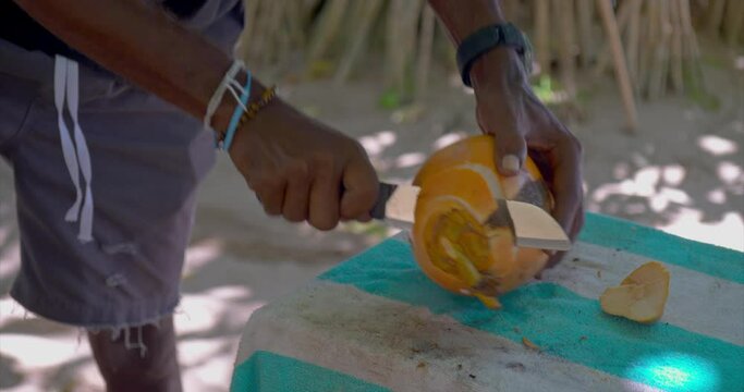 Man chopping fresh coconut close-up slow motion fresh coconut water pour Fresh coconut exotic fruits healthy tasty eating. Fresh coconut preparation taste of Sri Lanka's tropical bounty.