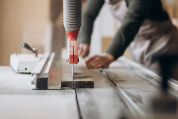 Carpenter working with wood and saw in the manufacturing industry
