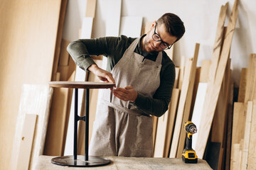 Carpenter with coffee table in the manufacturing