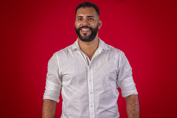 Man, with a beard, in a white shirt, with various facial expressions, on a red studio background