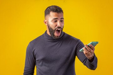 Man with a beard wearing a black shirt, holding a cell phone, with various facial expressions