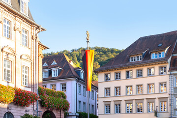 administration building German city of Heidelberg with long national flag, street of historic...