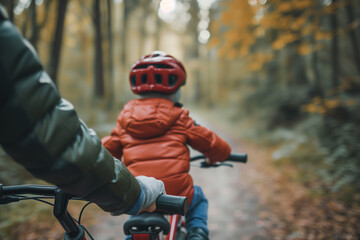 Focus on a parent's hand holding the back of a bicycle seat as a child pedals, capturing the moment of learning. - obrazy, fototapety, plakaty
