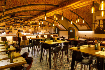 Interior of cozy modern restaurant with a bar counter and lamp lighting
