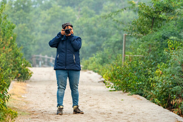 A female photographer taking photo of water birds at Bakkhali beach.