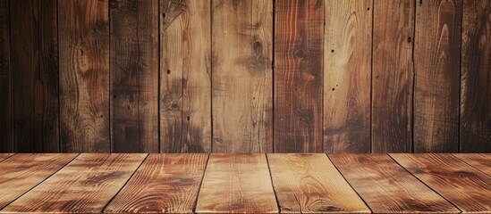 Top view of a wooden table against a wooden wall with a brown grain texture.