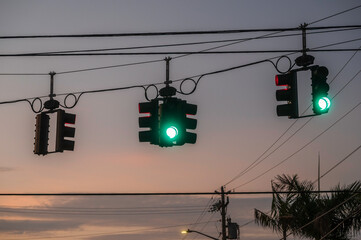 Traffic light with green light against the evening sky with sunset. 