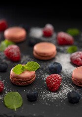macaroons of different colors on a black background