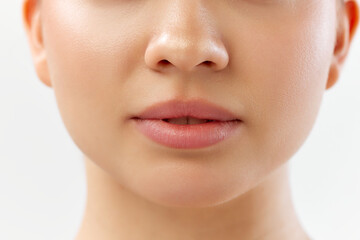 Close-up of lower face with focus on natural lips, clear skin and nose. Lip products ads. Skin clinic for treatments offering smooth, clear skin and healthy lips. Concept of skincare, cosmetology