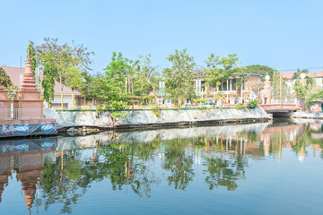Serene Khmer Temple by the Water in a Lush Garden Setting, Blending Ancient Architecture with...