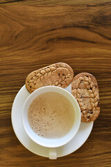Café con leche y galletas saludables en una mesa de madera, espacio para texto en la parte...