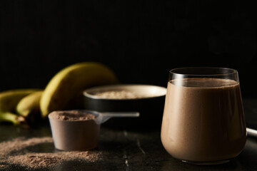 Chocolate Protein Power Cocktail with Ripe Bananas, Whole Oats, and Creamy Milk in a Modern Glass, Ideal for Post-Workout Recovery, Set Against a Dark, Textured Background