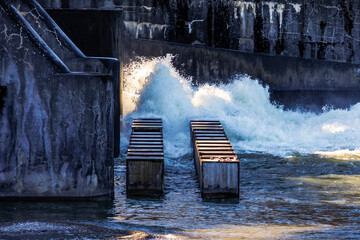 A weir in Augsburg over the river Lech is called the Hochablass and is a popular excursion destination under a bright blue sky - obrazy, fototapety, plakaty
