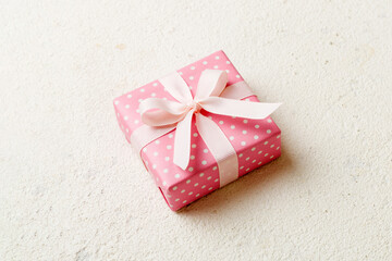 wrapped Christmas or other holiday handmade gift box in color paper with ribbon on colored...