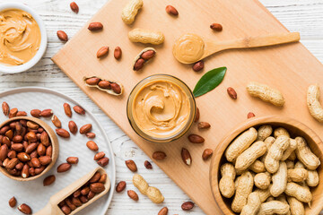 Bowl of peanut butter and peanuts on table background. top view with copy space. Creamy peanut pasta in small bowl