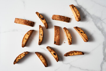 Scattered Almond and Cranberry Biscotti on Marble Surface, Aerial View with Elegant Shadows