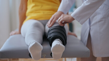 Close-up of an orthopedist removing a cast from a patient's leg, indicating bone fracture healing