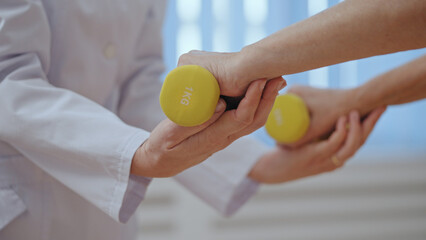 A physiatrist assists her senior patient with an orthopedic exercise, focusing on rehabilitation