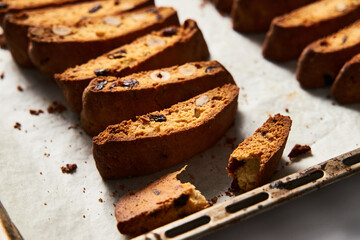 Fototapeta na wymiar Rows of Almond and Cranberry Biscotti Cooling on Parchment, Intimate Kitchen Atmosphere