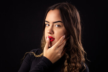 Happy young woman in black clothes on a black background with cinematic lighting