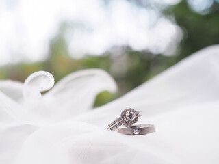 Diamond engagement wedding rings on bridal veil. Wedding accessories. Valentine's day and Wedding day concept.