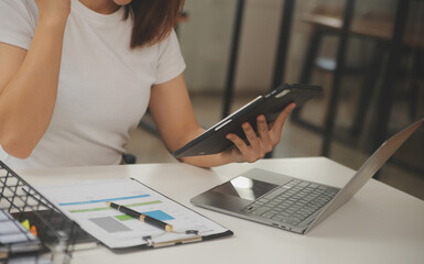 Fototapeta premium Young adult happy smiling Hispanic Asian student wearing headphones talking on online chat meeting using laptop in university campus or at virtual office. College female student learning remotely.