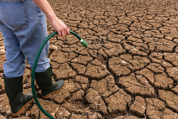 Person holding hose People in middle of dry field, weather problems, drought, bucket