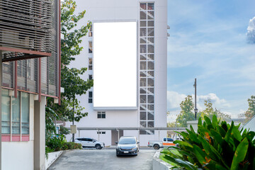 A large blank billboard stands on the side of a tall, modern building. The billboard is white with...