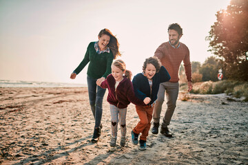 Happy young family walking on the beach